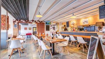 Ein modernes Restaurant mit Holztischen und -stühlen, einer Bar und einer Speisekarte.