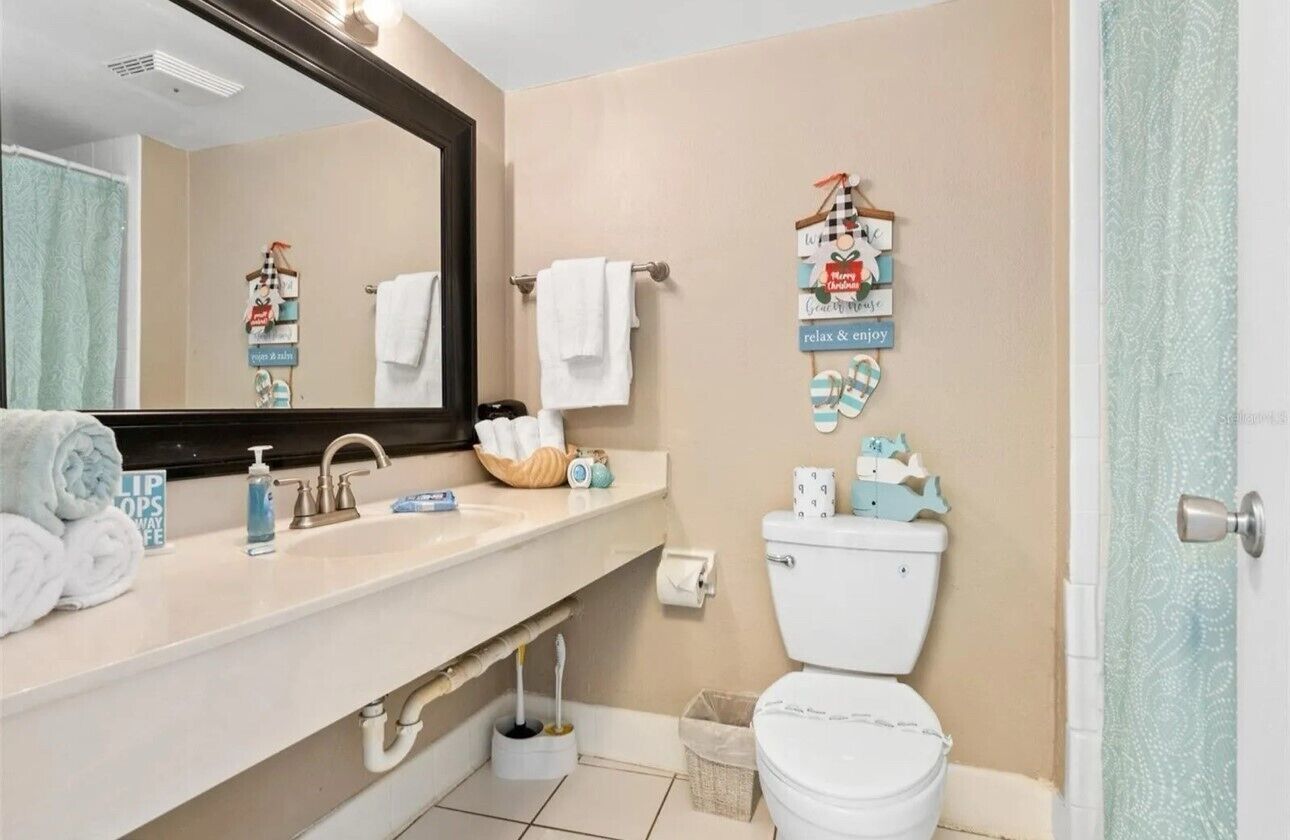Ein Badezimmer mit Waschbecken, Spiegel, Toilette und dekorativen Wandtafeln.