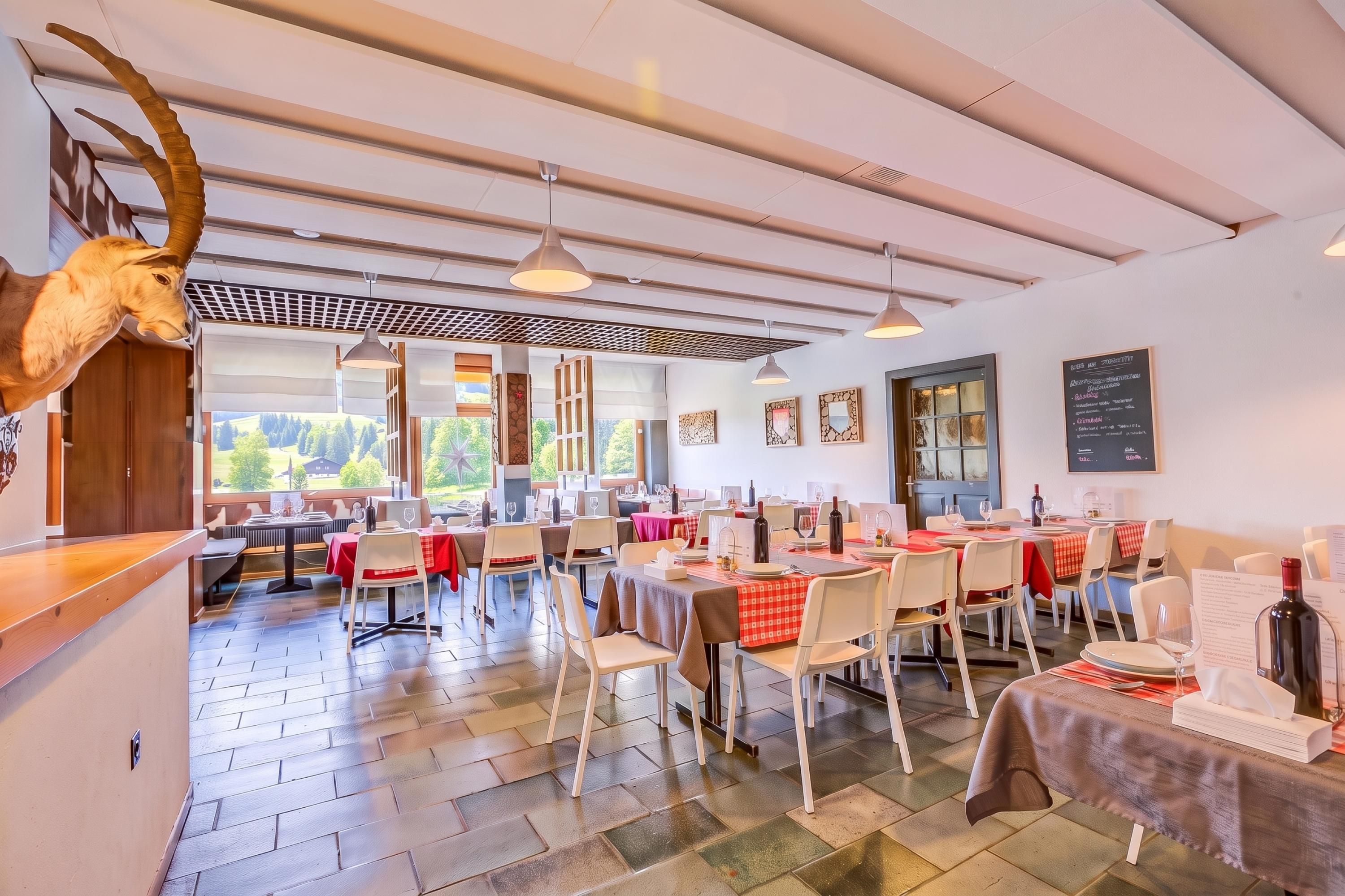 A restaurant with multiple tables, chairs, and a ceiling with exposed beams.