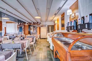 A restaurant with multiple dining tables, a buffet area, and a wall-mounted coffee station. - Hotel Relais Alpin Single Ski In-Out 4 220, Les Mosses, Switzerland (Les Mosses)