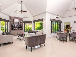 A spacious living area with a modern kitchen, large windows, and a dining area. - "Villa Sabai" mit Terrasse by Interhome (Pattaya)