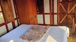 Een kamer met een bed, een houten garderobe en een houten wandpaneel.