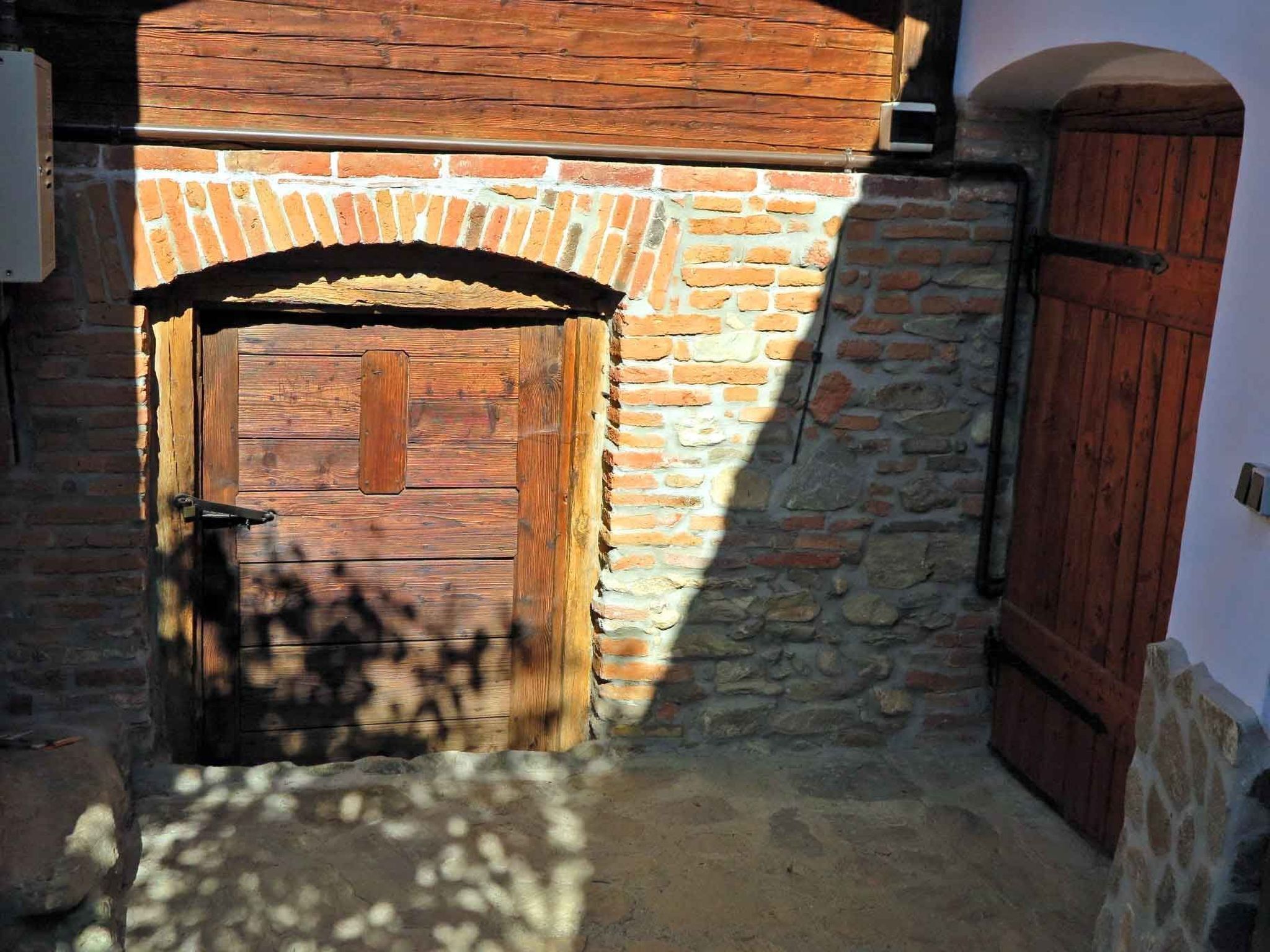 A narrow alleyway with a wooden door and a stone wall.