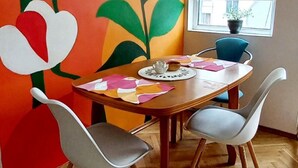 A dining area with a wooden table, four chairs, and a colorful mural on the wall. - Wohnung "Home of Joy Varna" by Interhome (Varna)