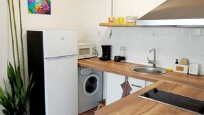 A compact kitchen with a washing machine, a refrigerator, and a wooden countertop. - Wohnung "Home of Joy Varna" by Interhome (Varna)