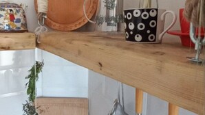 A kitchen shelf with a wooden cutting board, a glass teapot, a black and white mug, a plant, and kitchen utensils. - Wohnung "Home of Joy Varna" by Interhome (Varna)