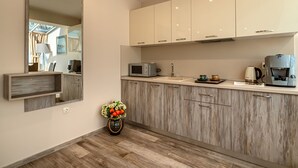 Una cucina moderna con mobili in legno, un forno a microonde, una macchina da caffè e un vaso con fiori.