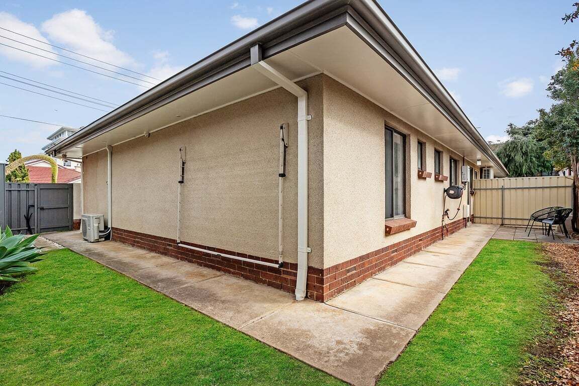 Une maison de plain-pied dotée d’un patio couvert, de fondations en briques et d’un petit jardin à l’avant.