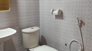 A bathroom with a toilet, sink, and bidet. - Toru Nibas Eco Resort Saint Martin (Cox's Bazar)