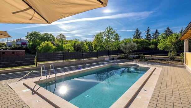 A rectangular swimming pool with a tiled edge, surrounded by a paved deck. - Villa Berton – Heated Saltwater Pool (Sveta Nedelja)