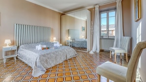 Une chambre d’hôtel avec un grand lit, une chaise, un miroir et une vue sur l’extérieur.