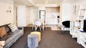 Un apartamento moderno con sala de estar, comedor, cocina y un pequeño espacio de oficina.