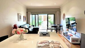 Un salon moderne avec une table à manger, un canapé et un téléviseur.