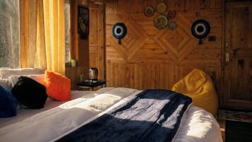Een houten kamer met een bed, kussens en een muur met ronde decoraties.