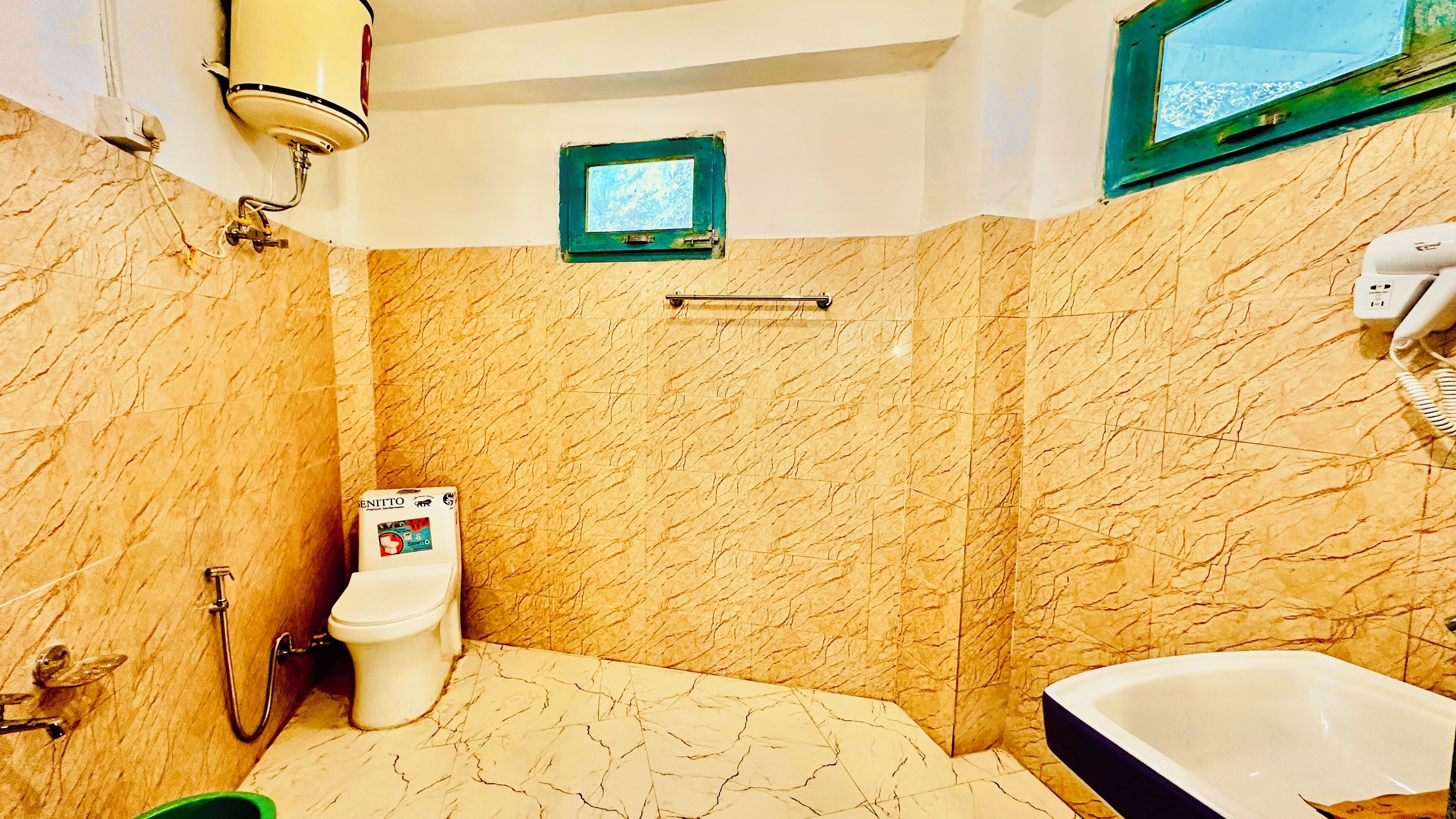 A bathroom with a toilet, a bathtub, and a shower area.