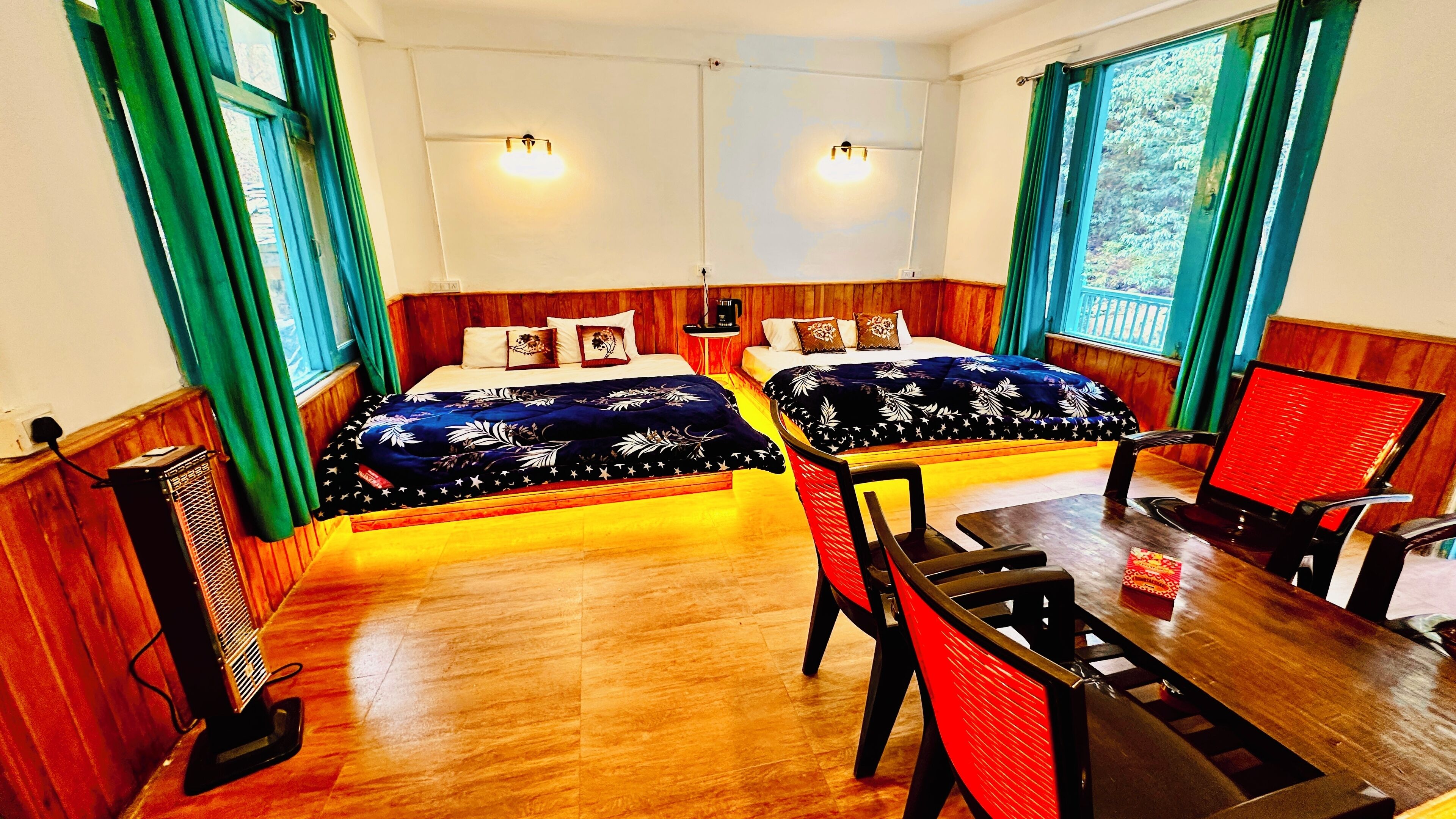 A room with two beds, a table, and chairs.
