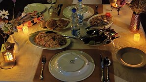 A dining table set with plates of food, cutlery, and water bottles. - Neel Hawa Beach resort Saint Martin (Saint Martin's Island)