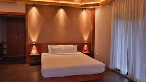A bedroom with a wooden headboard, two bedside lamps, a bed with white linens, and a large window with curtains. - Neel Hawa Beach resort Saint Martin (Saint Martin's Island)