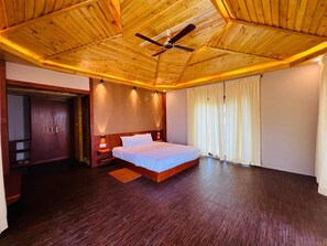 Ein Schlafzimmer mit Holzboden, einem Bett, einem Nachttisch und einem Kleiderschrank.