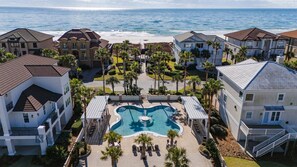 Ein Resort mit einem zentralen Pool, mehreren Gebäuden und Blick auf den Strand.
