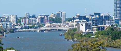 A cityscape with a river, modern buildings, and a bridge.