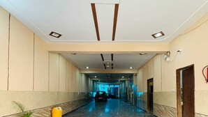 A long, polished marble hallway with a ceiling featuring recessed lighting and wooden beams. - Hotel Raghav Dham (Vrindavan)