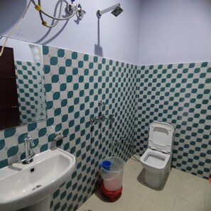 Un baño con suelo de baldosas a cuadros, un lavabo, un inodoro y una ducha.