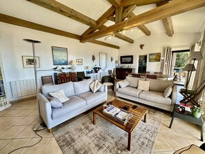 Ein geräumiges Wohnzimmer mit zwei Sofas, einem Couchtisch und einem Essbereich mit Tisch und Stühlen.