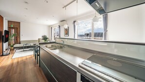 Eine moderne Küche mit einer großen Kochinsel, integrierten Geräten und Blick auf die Stadt.