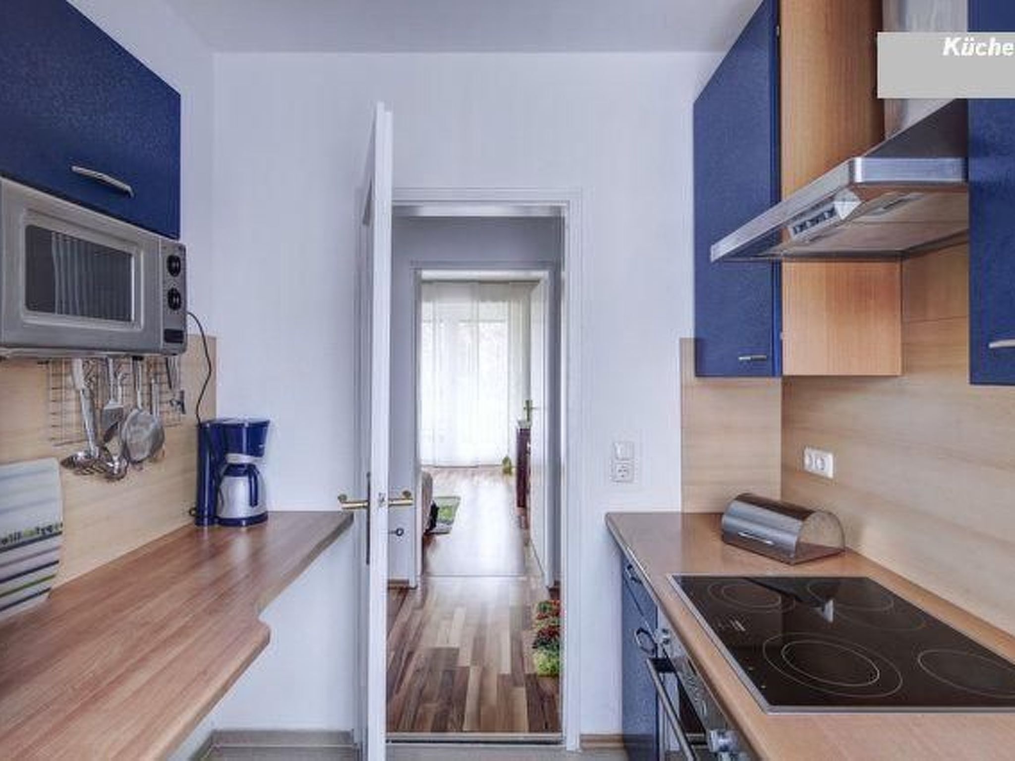 A modern kitchen with a microwave, coffee maker, and stove.