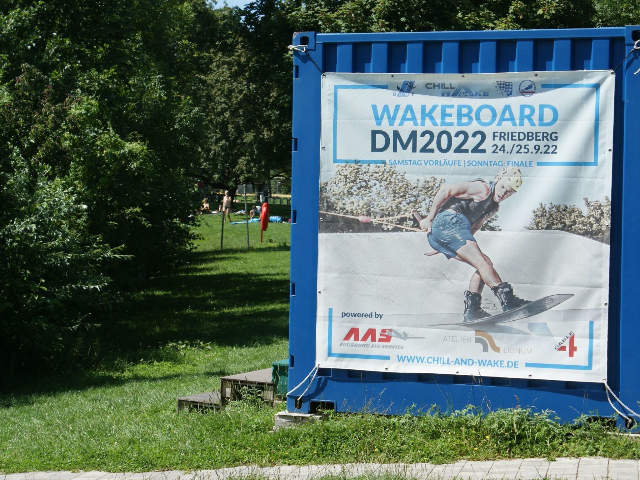 A wakeboarding event banner mounted on a blue structure.