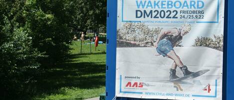 A wakeboarding event banner mounted on a blue structure.