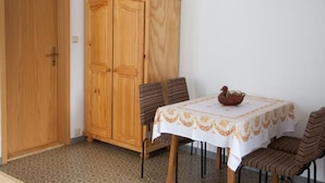 Ein Essbereich mit einem für vier Personen gedeckten Tisch, einem Holzschrank und einem Bodenbelag mit Muster.