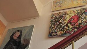 A staircase with a handrail and a painting on the wall.