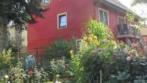 Ein rotes Haus mit zwei Fenstern und einem Balkon.