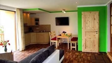 A compact living space with a kitchenette, a dining area, and a sofa.