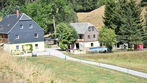 Un village rural avec des maisons, une route sinueuse et une zone herbeuse.