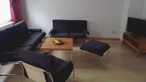 A living room with a sofa, two armchairs, a coffee table, and a TV stand. - Blaues Haus by Interhome (Meißen)