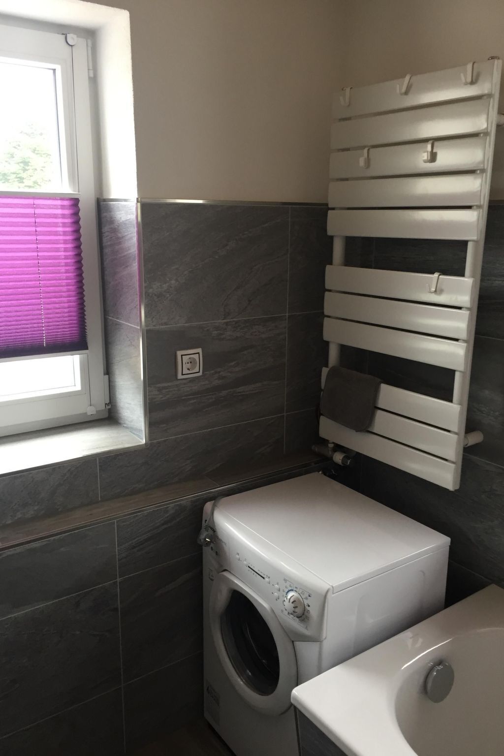 Ein kleiner Hauswirtschaftsraum mit Waschmaschine, Trockner und integriertem Handtuchhalter.