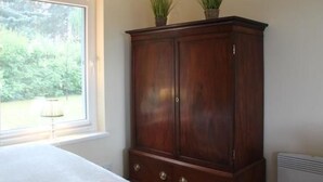 A room with a large window, a wooden cabinet, and a radiator.
