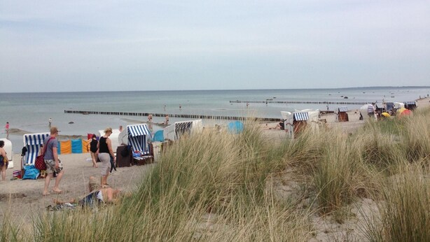 A beach with people, beach chairs, and umbrellas. - Appartement in Wismar mit Terrasse und Garten by Interhome (Wismar)