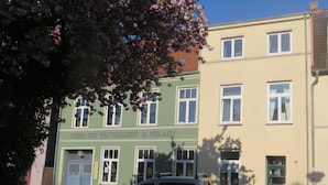A building with a sign reading "Möbel- und Bautischlerei M. Podlasly" and a parked van in front. - Appartement in Wismar mit Terrasse und Garten by Interhome (Wismar)