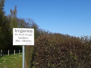 Schild für 'Irrgarten der Stadt Dargun', geöffnet von Mai bis Oktober.