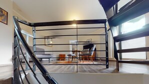Un interior moderno con una escalera, un comedor y una sala de estar.
