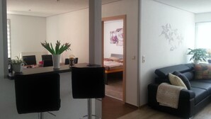A modern living room with a sofa, a coffee table, and a dining area with a table and chairs. - Waldperle by Interhome (Altwarp)