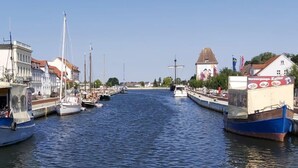 A canal with boats docked on both sides, surrounded by buildings with a mix of architectural styles. - Waldperle by Interhome (Altwarp)