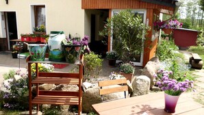A patio with wooden furniture, potted plants, and a small table. - Schiemann by Interhome (Karnin)