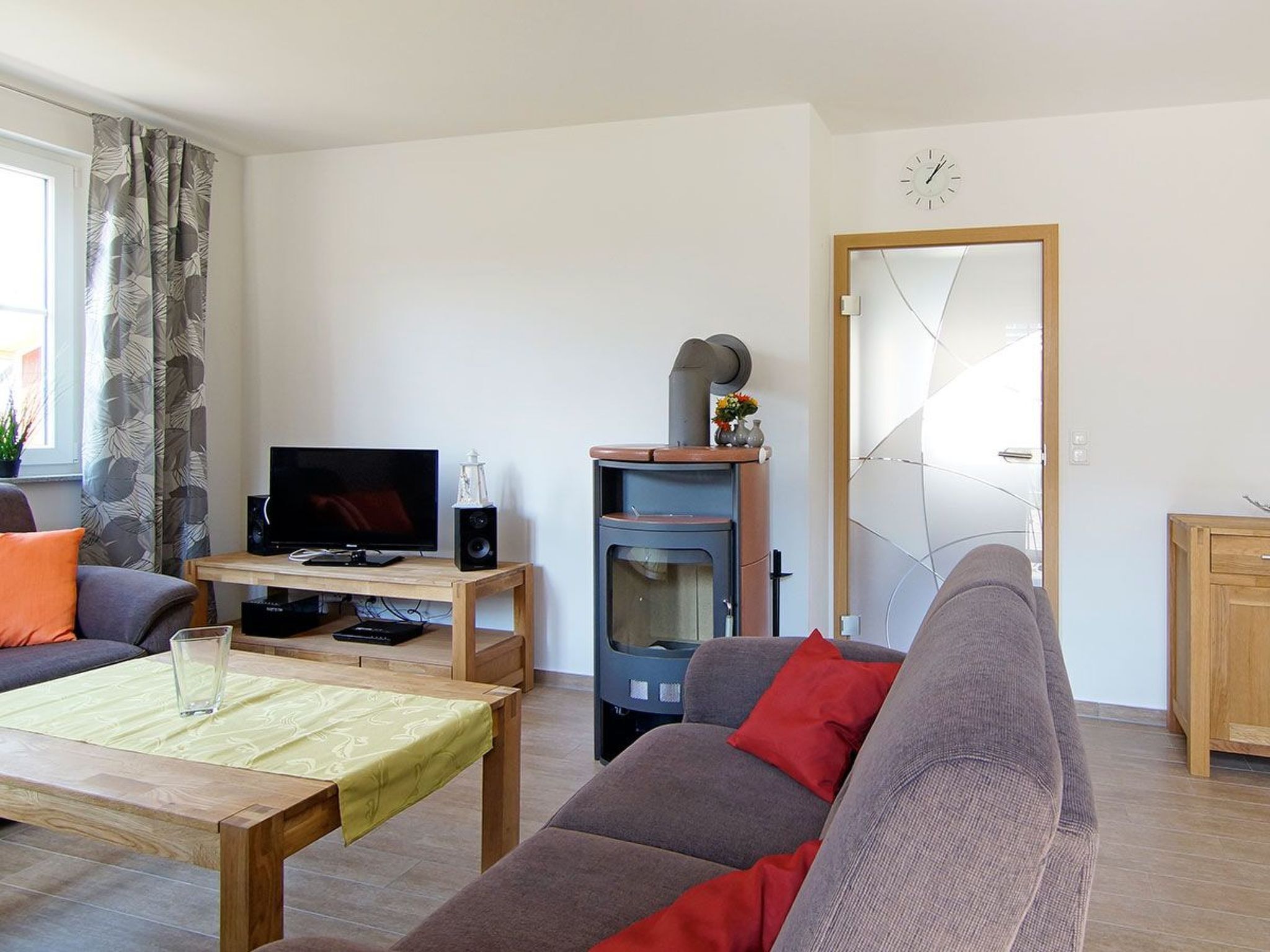 Un salon comprenant un canapé, une table basse, un téléviseur, un haut-parleur et une cheminée.
