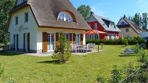 A traditional building with a thatched roof, a small garden, and outdoor seating. - Orchidee in Glowe by Interhome (Glowe)