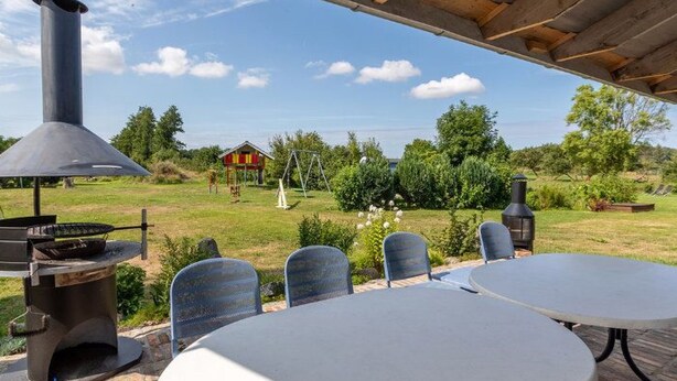 Un patio al aire libre con suelo de ladrillo, una mesa redonda y dos sillas.